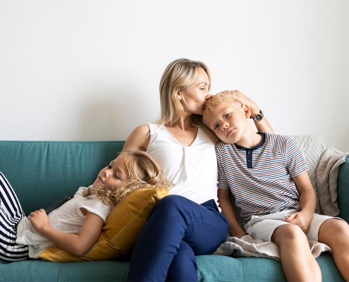 mother sitting on a couch with her children