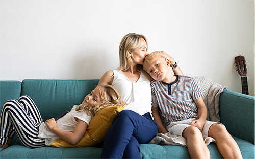 mother on a couch holding her children